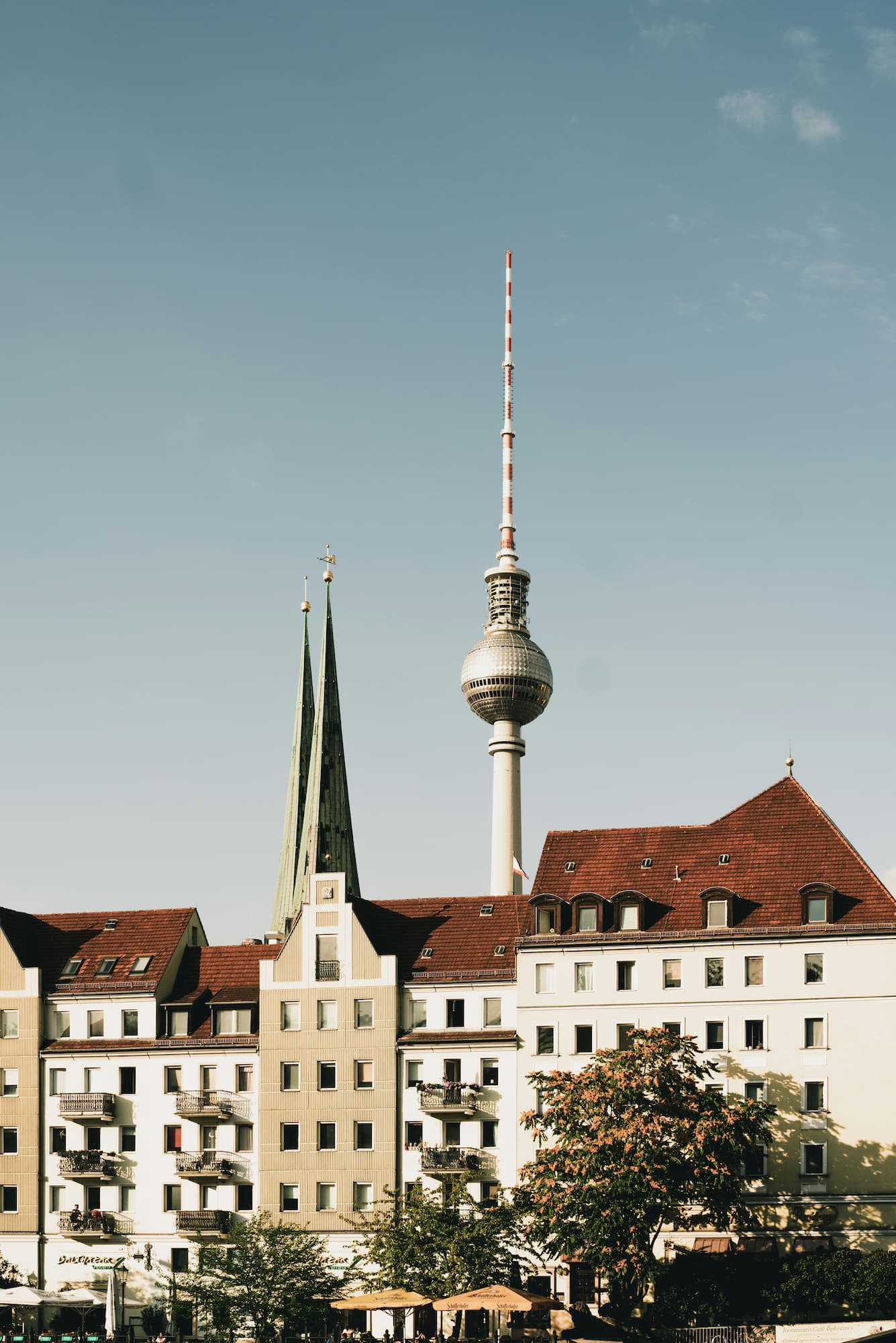 Berliner Fernsehturm und Türme der Nikolaikirche über historischen Dächern